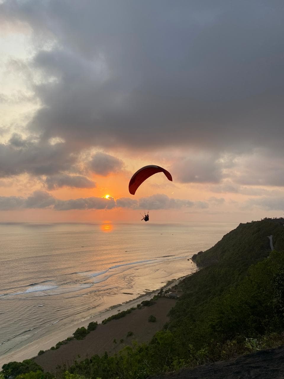 Scenic Bali paragliding flight at sunset over the ocean
